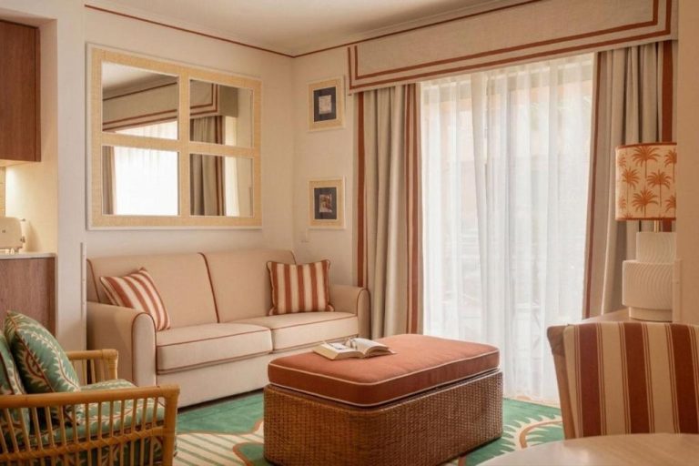 Salón de suite con sofá beige y ottomana en el Grande Real Santa Eulalia Resort & Hotel Spa