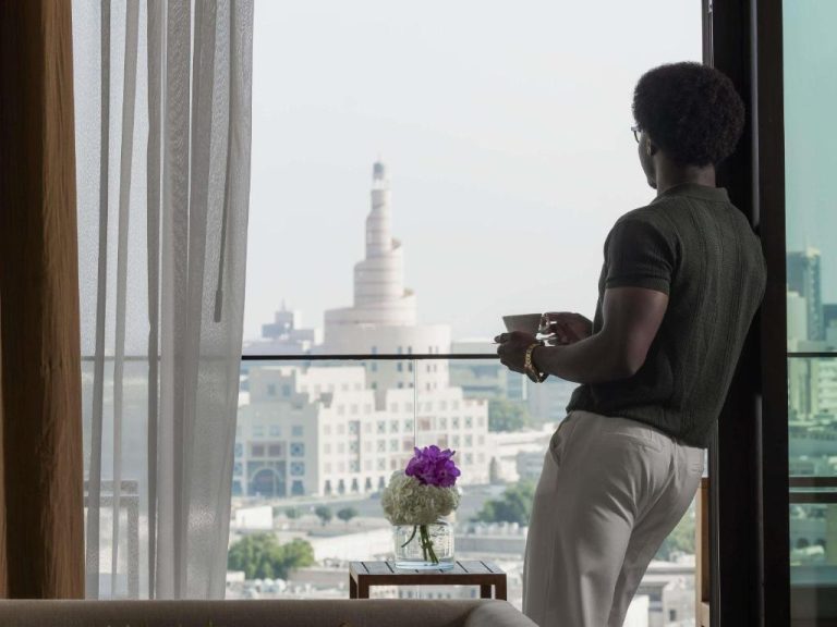 Huésped disfrutando de las vistas a la ciudad desde su habitación en Alwadi Hotel Doha MGallery