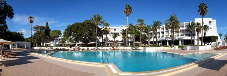 Amplia piscina exterior con tumbonas y palmeras del Hotel Bel Azur Thalasso & Bungalows en Túnez