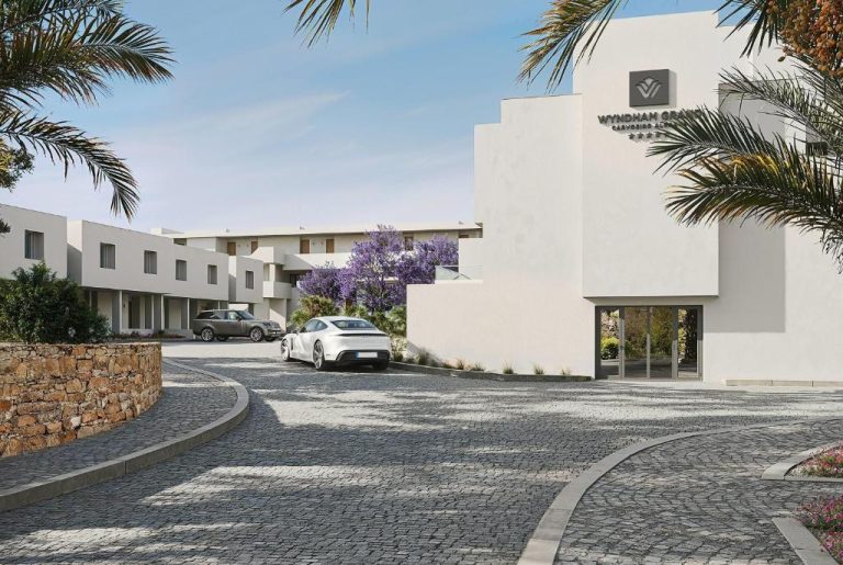 Entrada principal del Wyndham Grand Carvoeiro Algarve con acceso en adoquines y palmeras