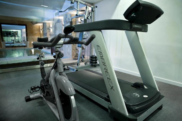 Gimnasio con cinta de correr Embreex y bicicleta estática en Awwa Suites & Spa