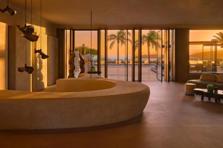 Recepción circular del Minos Palace Resort Adults Only con vistas al mar y palmeras al atardecer