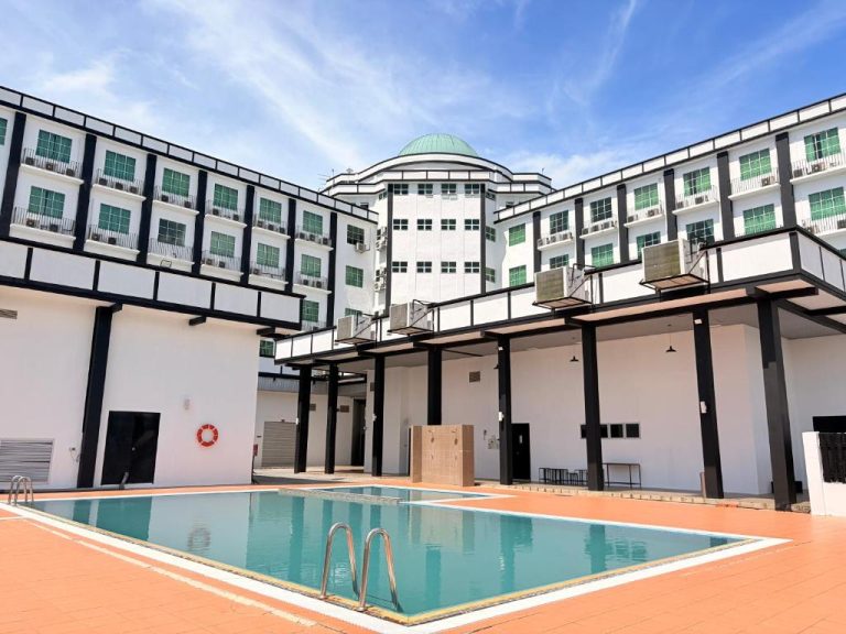 Piscina exterior con zona de descanso y edificio principal del Hotel Seri Malaysia Lawas