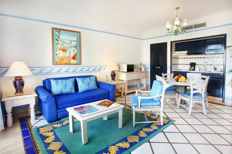 Salón con sofá azul y cocina integrada en el Pueblo Bonito Los Cabos Blanco Beach Resort All Inclusive