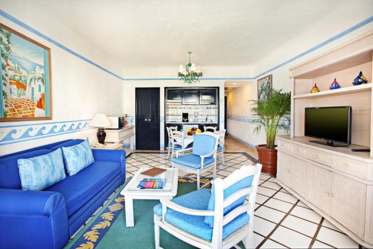 Sala de estar con sofá azul y cocina integrada en Pueblo Bonito Los Cabos Blanco Beach Resort