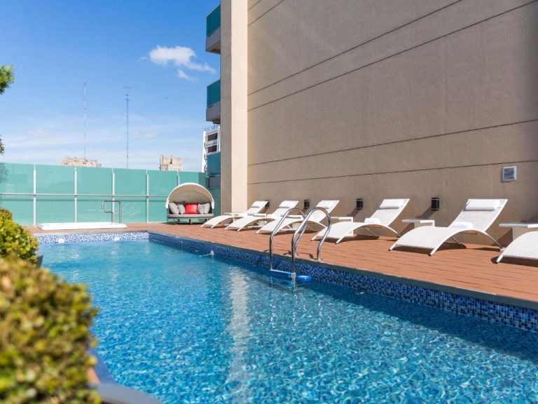 Piscina exterior con tumbonas y terraza de madera en Palladio Hotel Buenos Aires MGallery Collection