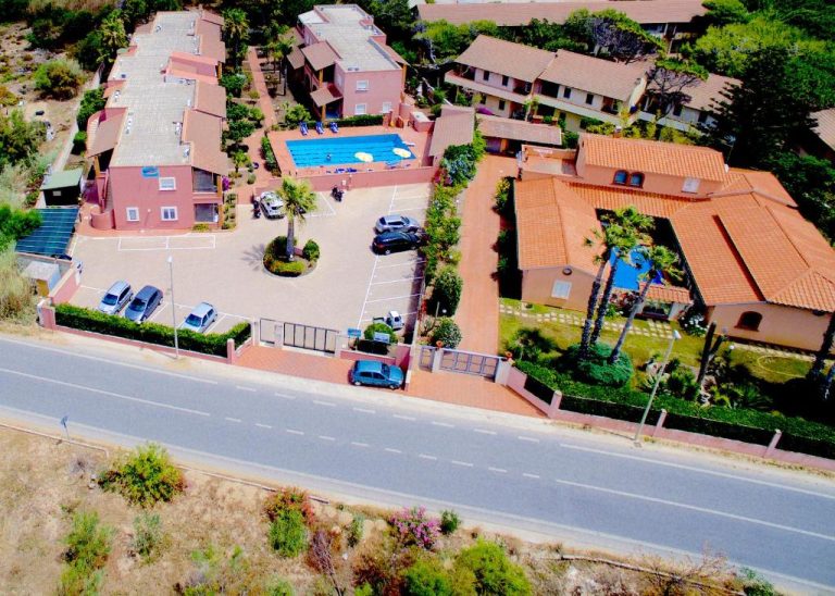 Vista aérea de Le Dune Residence con piscina exterior, aparcamiento y jardines en Cerdeña