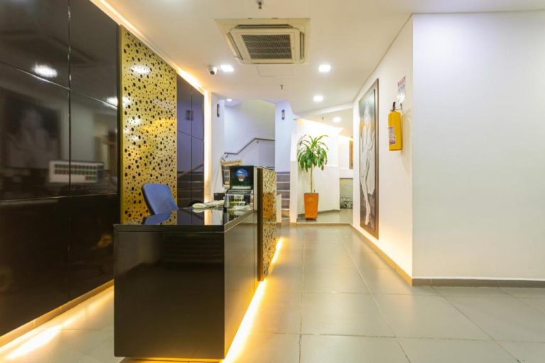 Recepción moderna con mostrador negro e iluminación dorada del Hotel Zona Express San Diego