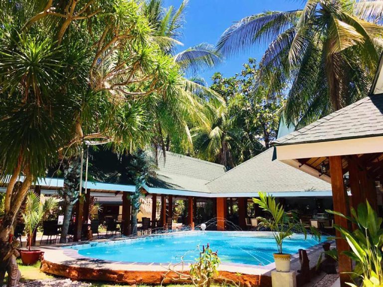 Piscina exterior con fuentes y palmeras tropicales del Paradise Garden Hotel and Convention Center Boracay