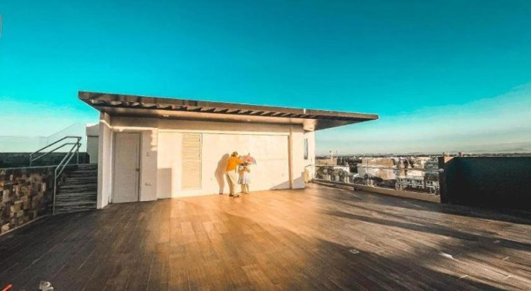 Terraza panorámica con suelo de madera y vistas a la ciudad en Lavero Suites