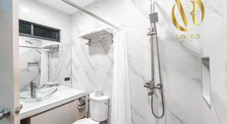 Baño moderno con revestimiento de mármol blanco y ducha en Lavero Suites