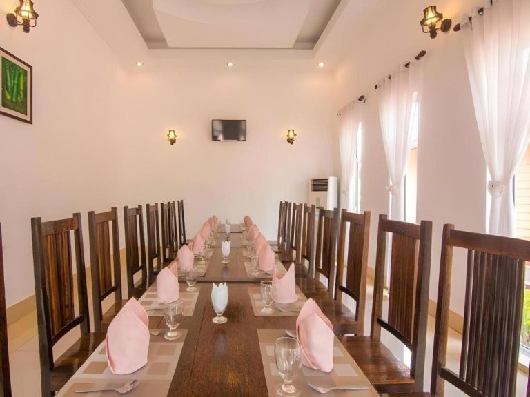Salón comedor privado con mesa larga y sillas de madera elegantes en el Sambopich Chenla Hotel