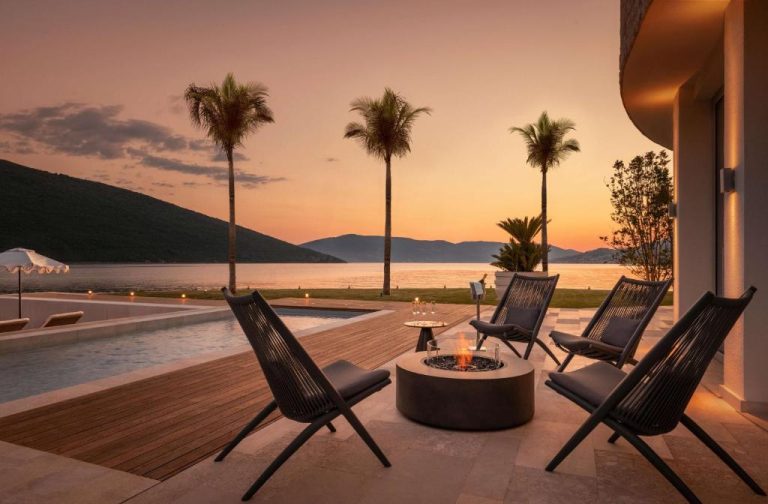 Terraza con hoguera y piscina exterior al atardecer en el resort One&Only Portonovi, Montenegro