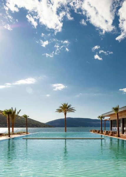 Piscina infinita con palmeras y vistas a la bahía en el resort One&Only Portonovi, Montenegro
