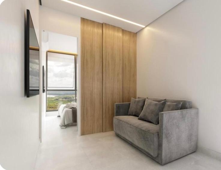 Sala de estar moderna con sofá gris y paneles de madera en Apartamento no Beach Resort Salinas