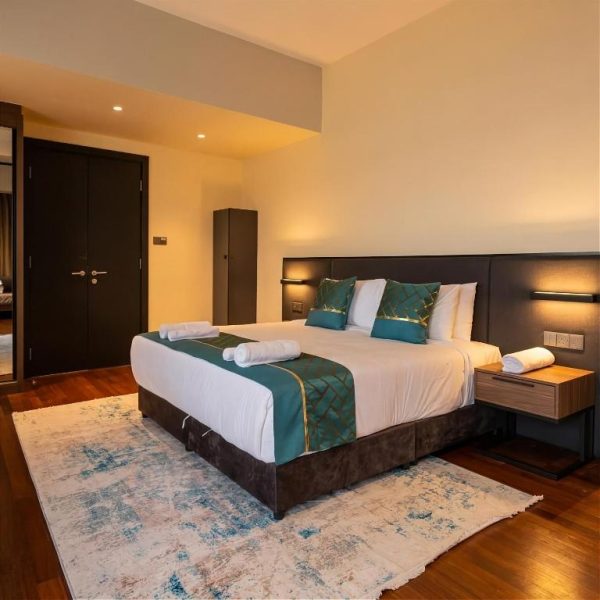 Habitación de lujo con cama doble y decoración en verde esmeralda del Golden Palm Tree Suite en Sepang, Malasia