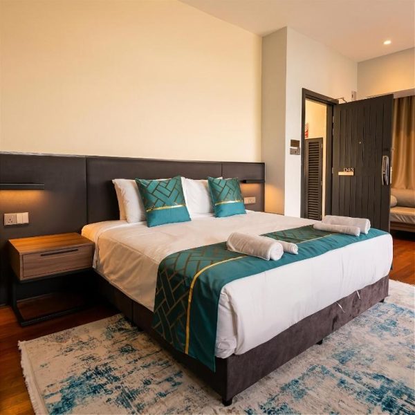 Habitación de lujo con cama king size y decoración en verde esmeralda del Golden Palm Tree Suite en Sepang