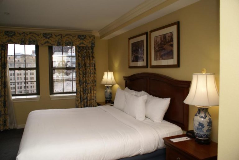 Habitación con cama king size, lámparas decorativas y vistas a la ciudad en el Columbia Club