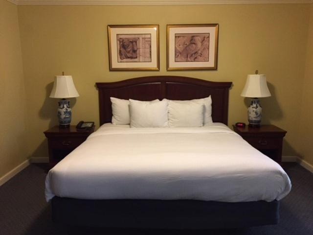 Habitación con cama king size y lámparas clásicas en el Columbia Club Hotel