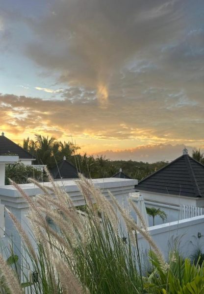 Villas con tejados negros y jardines tropicales al atardecer en Kelingking Green Village