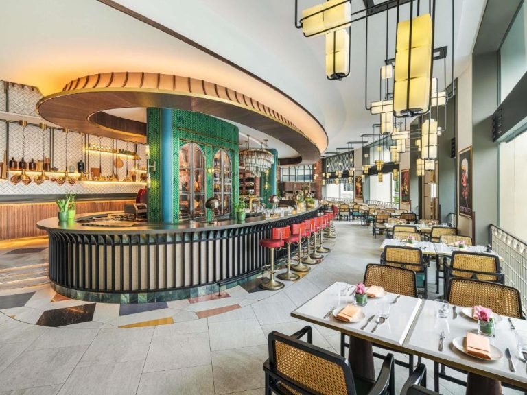 Elegante restaurante con barra circular y decoración art déco en el Fairmont Singapore