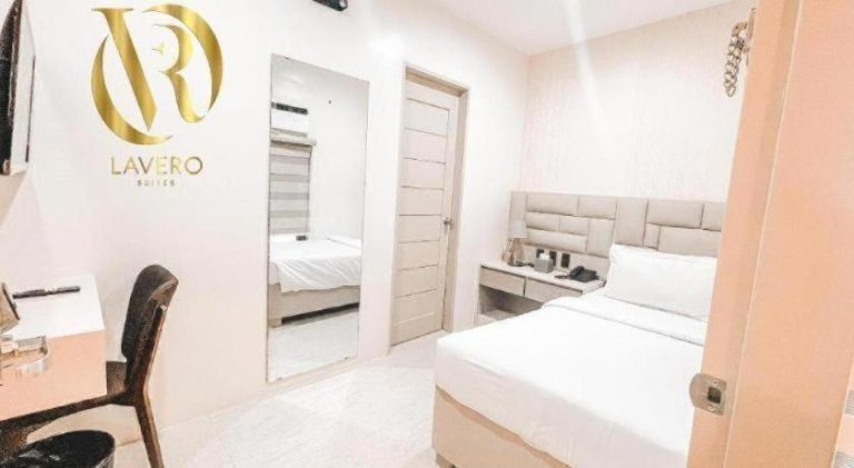 Habitación doble moderna con cama y espejo de cuerpo entero en Lavero Suites