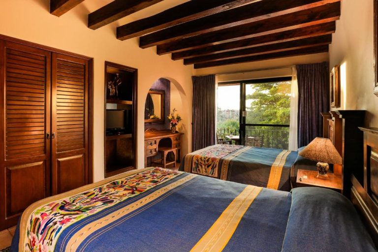 Habitación doble con vigas de madera y decoración mexicana tradicional en Hotel Lunata 5th Avenue