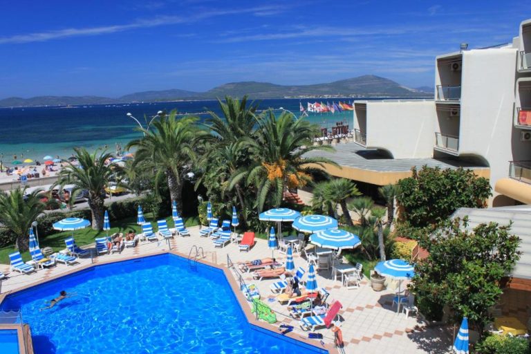 Piscina exterior con tumbonas y sombrillas del Hotel Florida junto a la playa y vistas al mar