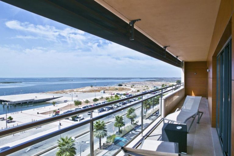 Terraza con tumbonas y vistas panorámicas al mar y puerto en Real Marina Hotel & Spa