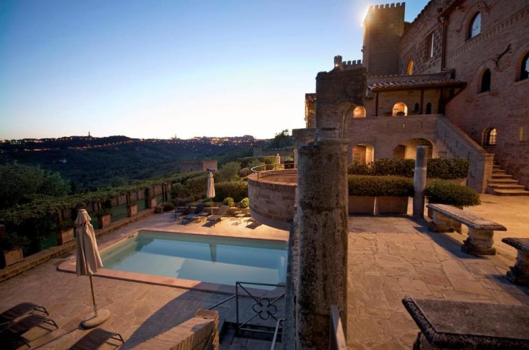 Piscina exterior con vistas al valle y arquitectura medieval del Castello di Monterone en Perugia