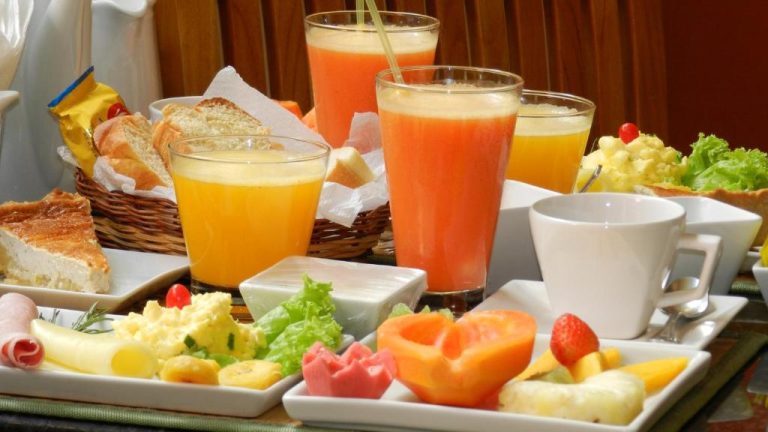 Desayuno buffet con zumos naturales, frutas frescas y pan en Hotel Casa do Amarelindo