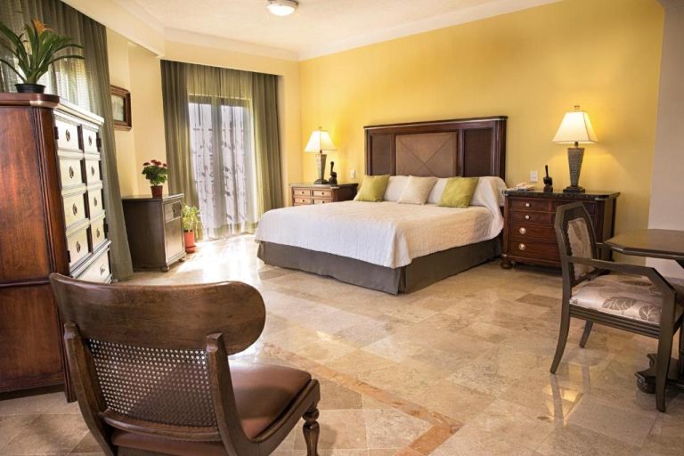 Habitación deluxe con cama king size y decoración colonial en Hotel Los Itzaes by 5th Av