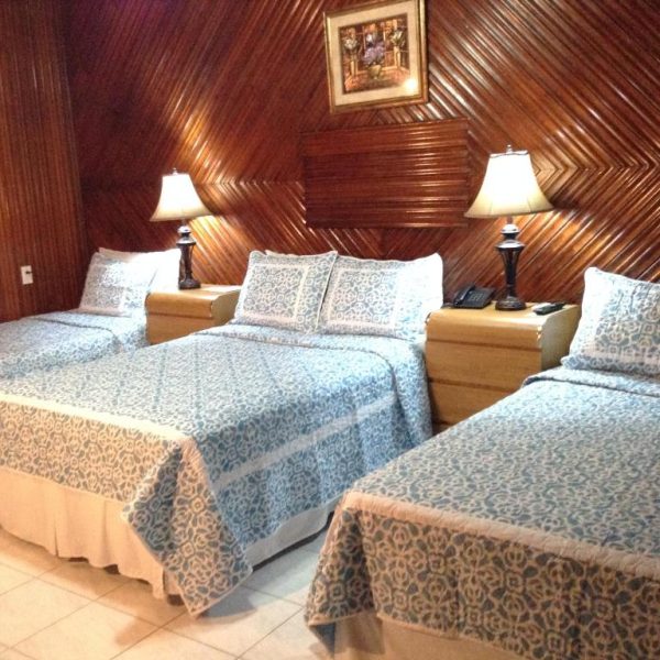 Habitación doble con dos camas y decoración en madera del Hotel Cafe