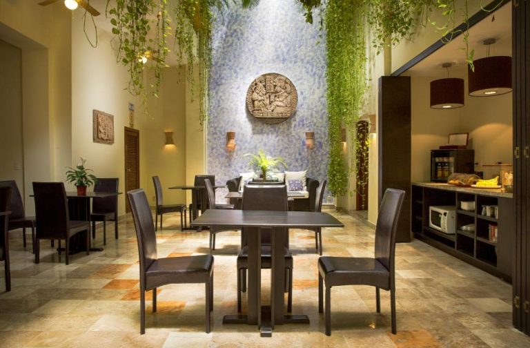 Restaurante con jardín interior colgante y decoración maya en Hotel Los Itzaes by 5th Av