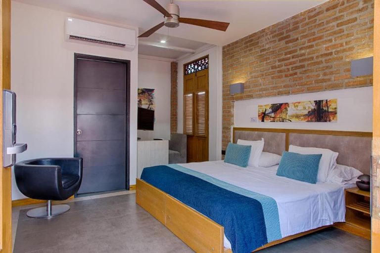 Habitación doble con pared de ladrillo y cama king en Hotel Boutique Casa Carolina Santa Marta