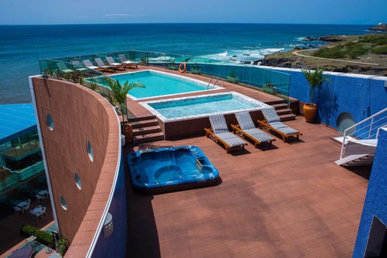 Terraza con piscina infinita, jacuzzi y tumbonas del Hotel Vip Praia con vistas al océano