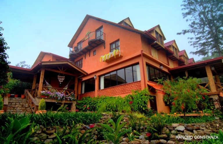 Fachada exterior del Hotel Rancho Constanza & Cabañas de la Montaña rodeada de jardines y vegetación tropical