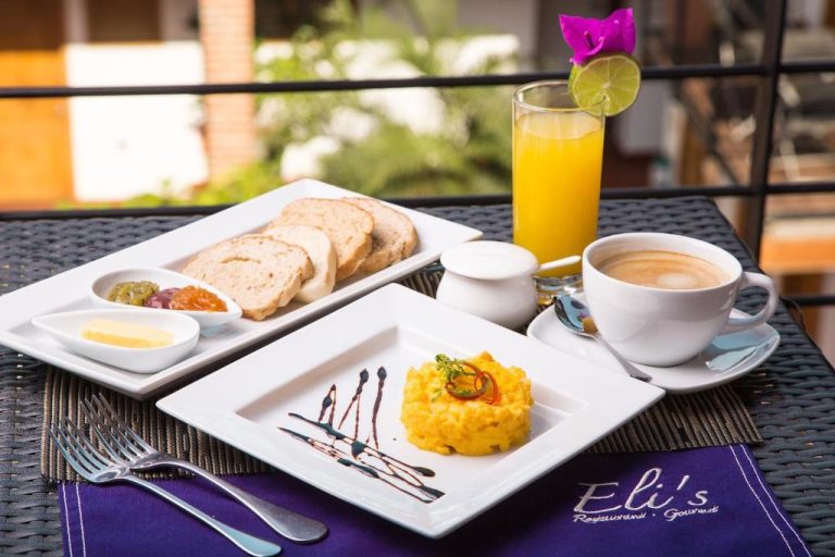 Desayuno gourmet con huevos revueltos, tostadas y jugo de naranja en Hotel Boutique Casa Carolina Santa Marta