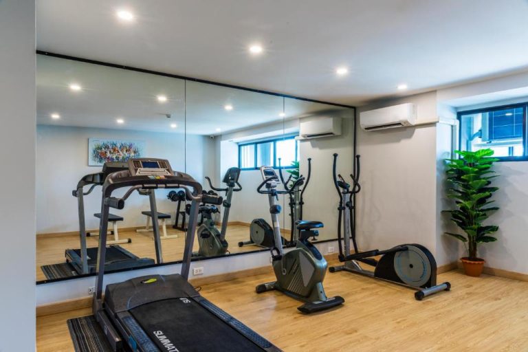 Gimnasio moderno con cinta de correr y bicicleta estática en Livotel Hotel Hua Mak Bangkok
