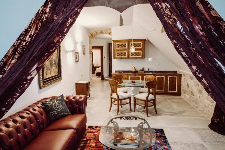 Lujosa suite con sofá Chesterfield, mesa de cristal y cocina integrada en Villa Nepos Hotel