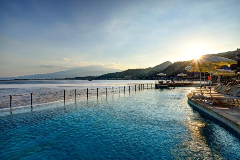 Piscina infinita con vistas al mar al atardecer en UNA Hotels Capotaormina, Sicilia