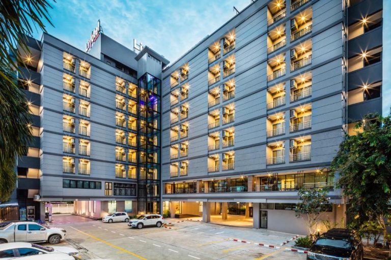 Fachada exterior iluminada del Livotel Hotel Hua Mak Bangkok con aparcamiento y múltiples plantas