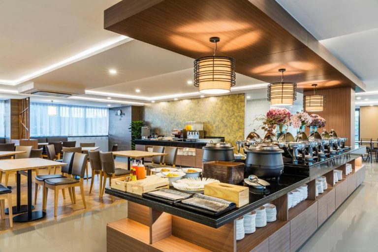 Restaurante buffet con zona de comida caliente y mesas del Livotel Hotel Hua Mak Bangkok