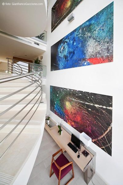 Escalera de caracol y obras de arte abstracto en la recepción del Eureka Palace Hotel Spa