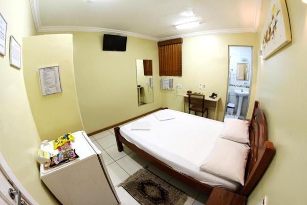 Habitación doble con cama matrimonial de madera y baño privado en Hotel Belem Fortaleza