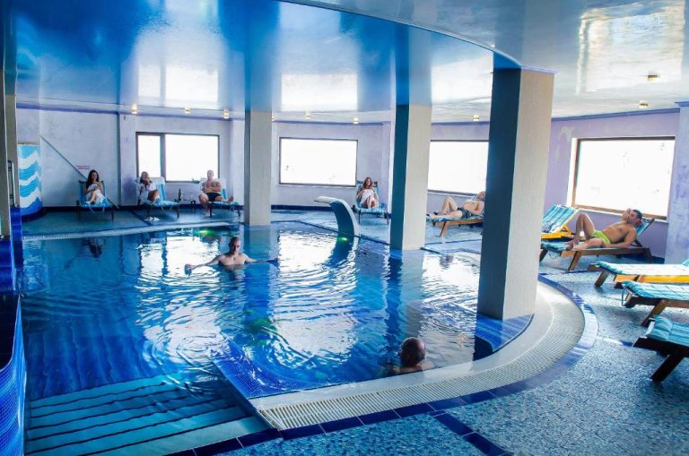 Piscina interior climatizada con tumbonas y columnas del Park Hotel Stara Zagora
