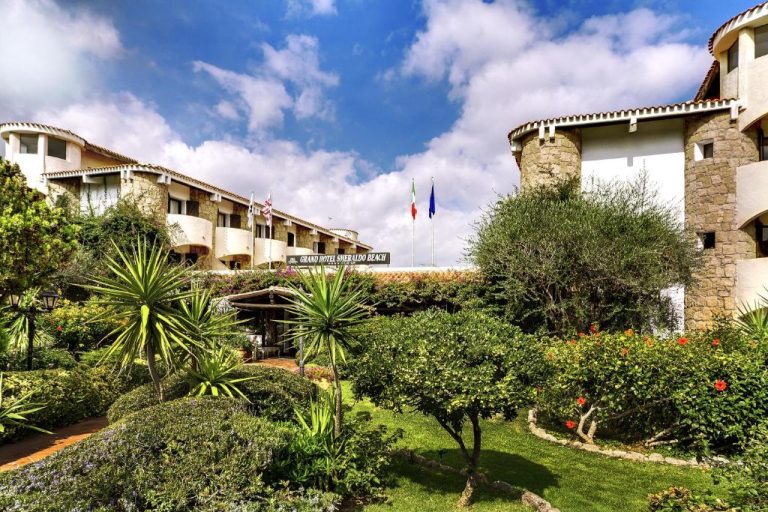 Fachada exterior con jardines mediterráneos del Grand Hotel Smeraldo Beach en Cerdeña