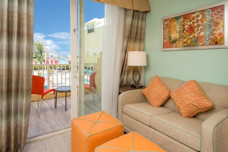 Sala de estar con sofá y terraza con vistas a la piscina en Holiday Inn Express & Suites Nassau