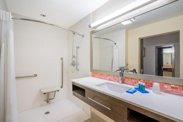 Baño accesible con ducha adaptada y barras de apoyo en Holiday Inn Express & Suites Nassau by IHG