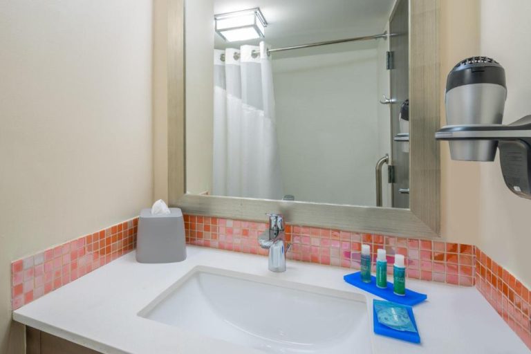 Baño moderno con lavabo, espejo y amenities del Holiday Inn Express & Suites Nassau